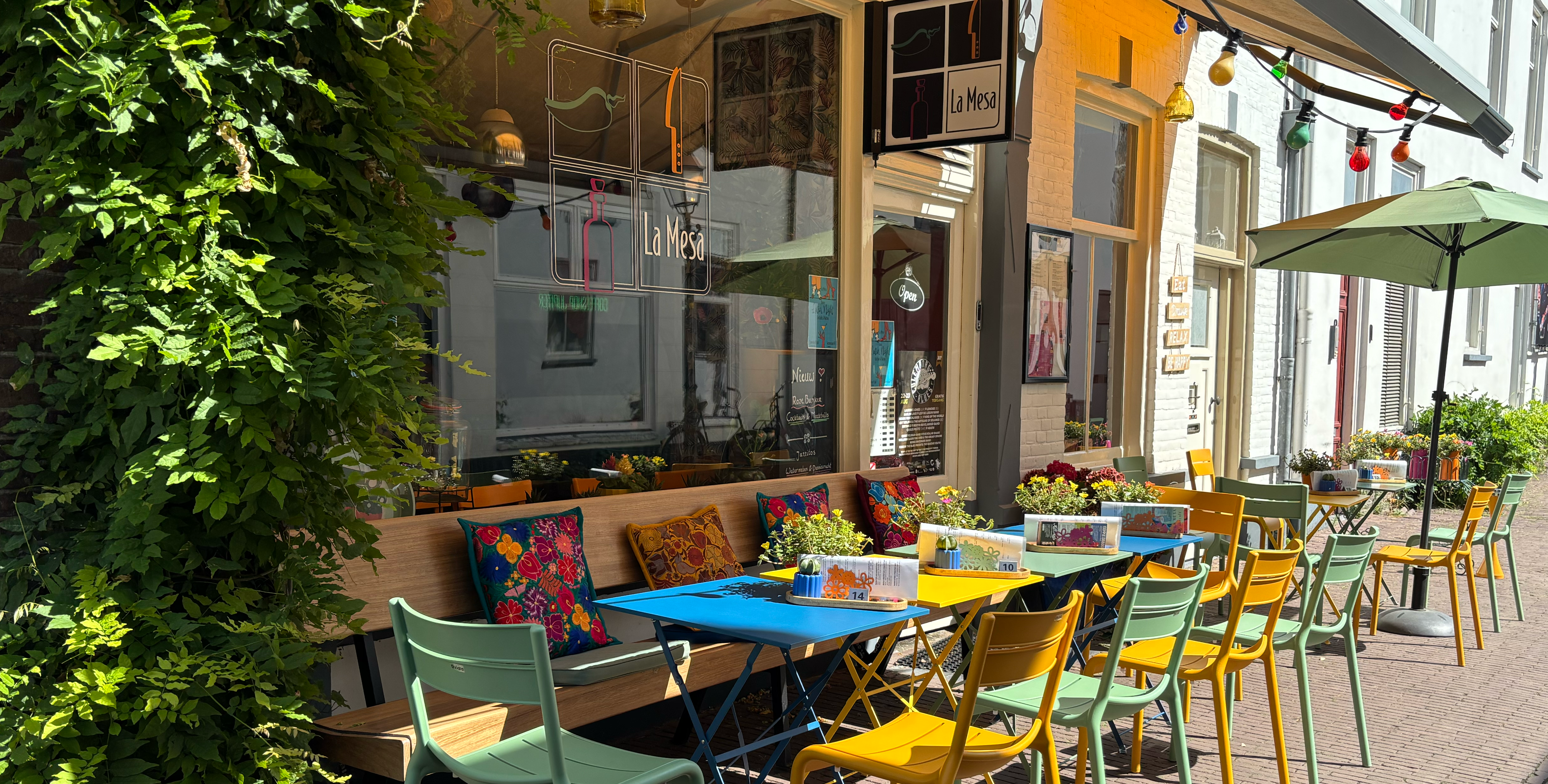 La Mesa terras met kleurrijke tafels en stoelen