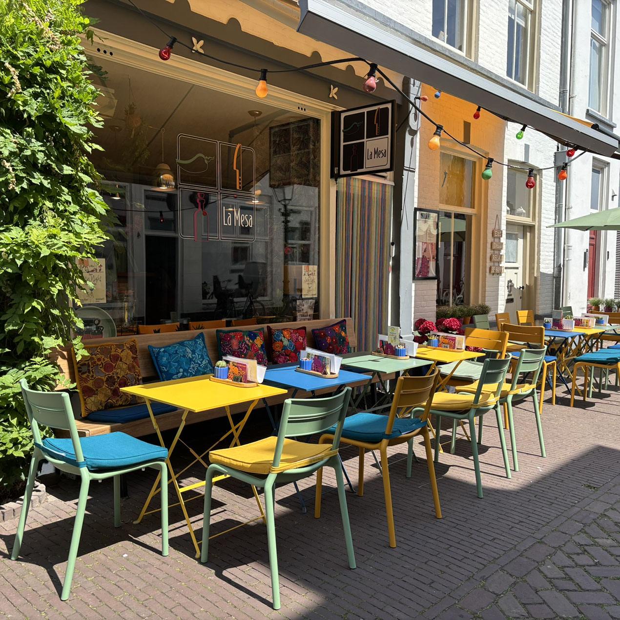 La Mesa terras met kleurrijke tafels en stoelen